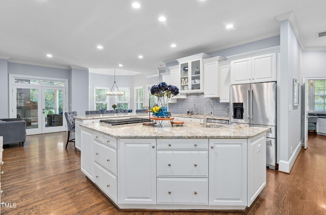 114 Kendleton Pl, Cary, NC 27518 - kitchen with stainless steel appliances, ornamental molding, an island with sink, white cabinetry, and dark wood-type flooring
