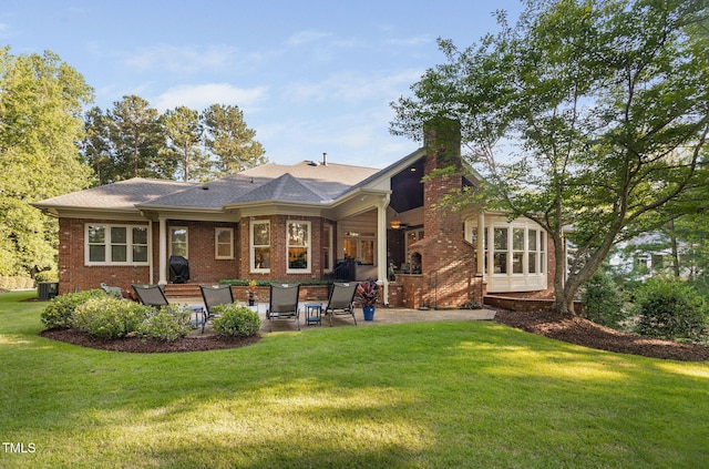114 Kendleton Pl, Cary, NC 27518 - back of house featuring a patio area, a chimney, a lawn, and brick siding