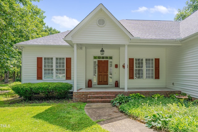 300 Williamston Ridge Dr, Youngsville, NC 27596 - doorway to property with covered porch, roof with shingles, and a yard