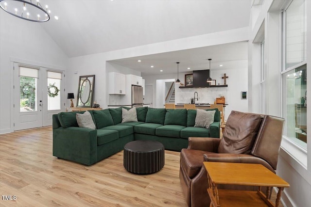 88 Priscilla Ln, Fuquay Varina, NC 27526 - living room featuring high vaulted ceiling, light wood-type flooring, stairs, recessed lighting, and a chandelier