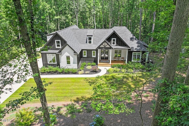 88 Priscilla Ln, Fuquay Varina, NC 27526 - view of front of home with a front yard, covered porch, roof with shingles, and a wooded view