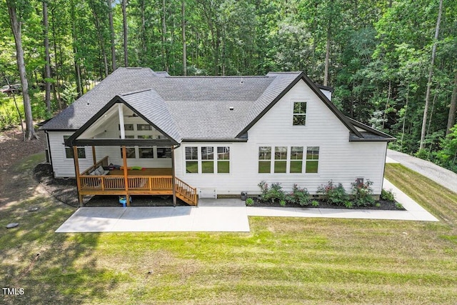 88 Priscilla Ln, Fuquay Varina, NC 27526 - back of property with a shingled roof, a wooden deck, a yard, a forest view, and a patio