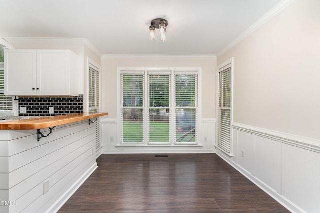 1006 Mingo Pl, Knightdale, NC 27545 - unfurnished dining area with ornamental molding, a wainscoted wall, and dark wood-type flooring