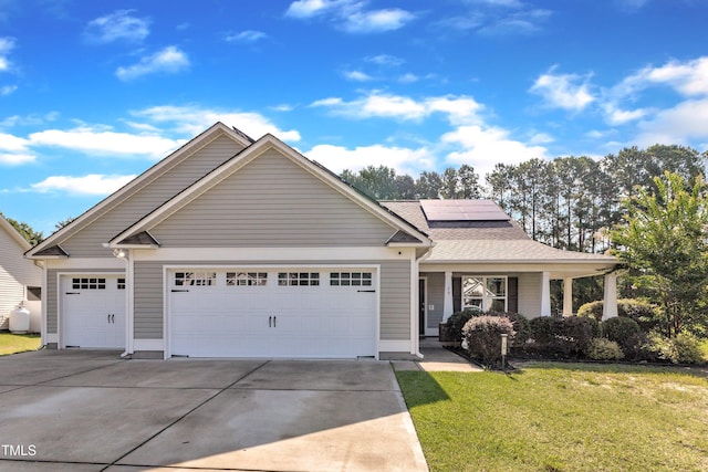 39 All Aboard Cir, Willow Springs, NC 27592 - view of front of house with a garage, concrete driveway, a front yard, solar panels, and covered porch