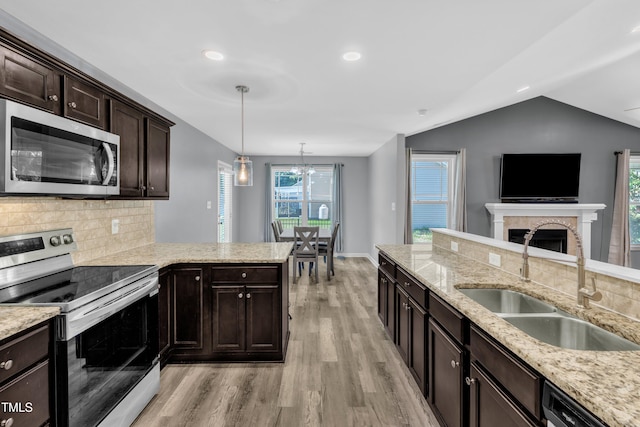 39 All Aboard Cir, Willow Springs, NC 27592 - kitchen with stainless steel appliances, light wood-style floors, tasteful backsplash, dark brown cabinets, and vaulted ceiling