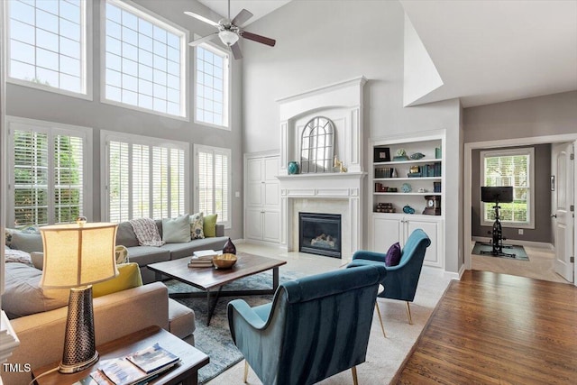 2941 Grandview Heights Ln, Raleigh, NC 27614 - living room with light wood-style floors, a high end fireplace, ceiling fan, a high ceiling, and built in shelves