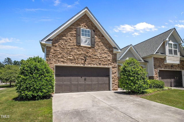 5216 Marcella Ct, Durham, NC 27707 - view of front facade with stone siding, a garage, concrete driveway, and a front lawn