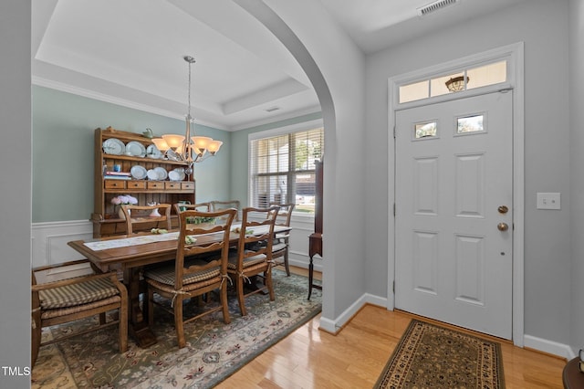 5216 Marcella Ct, Durham, NC 27707 - entryway with arched walkways, a tray ceiling, light wood-type flooring, and a chandelier