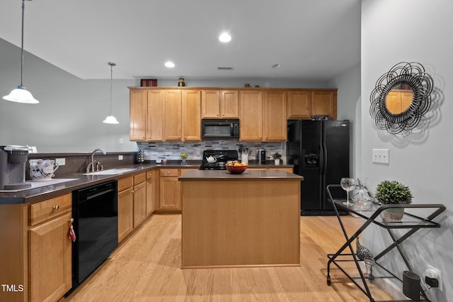5216 Marcella Ct, Durham, NC 27707 - kitchen featuring black appliances, dark countertops, a peninsula, light wood-type flooring, and backsplash
