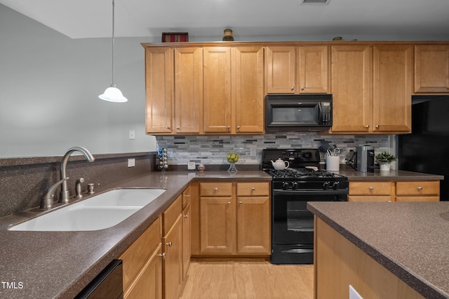 5216 Marcella Ct, Durham, NC 27707 - kitchen with black appliances, dark countertops, light wood-style flooring, and backsplash