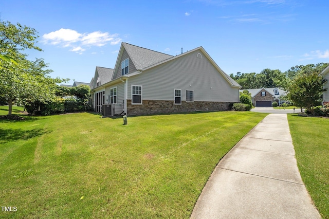 5216 Marcella Ct, Durham, NC 27707 - view of side of home with a yard, stone siding, a garage, and roof with shingles