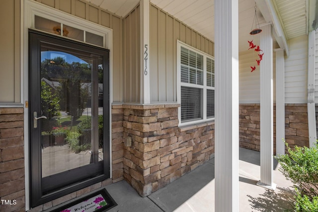5216 Marcella Ct, Durham, NC 27707 - doorway to property featuring covered porch, board and batten siding, and brick siding