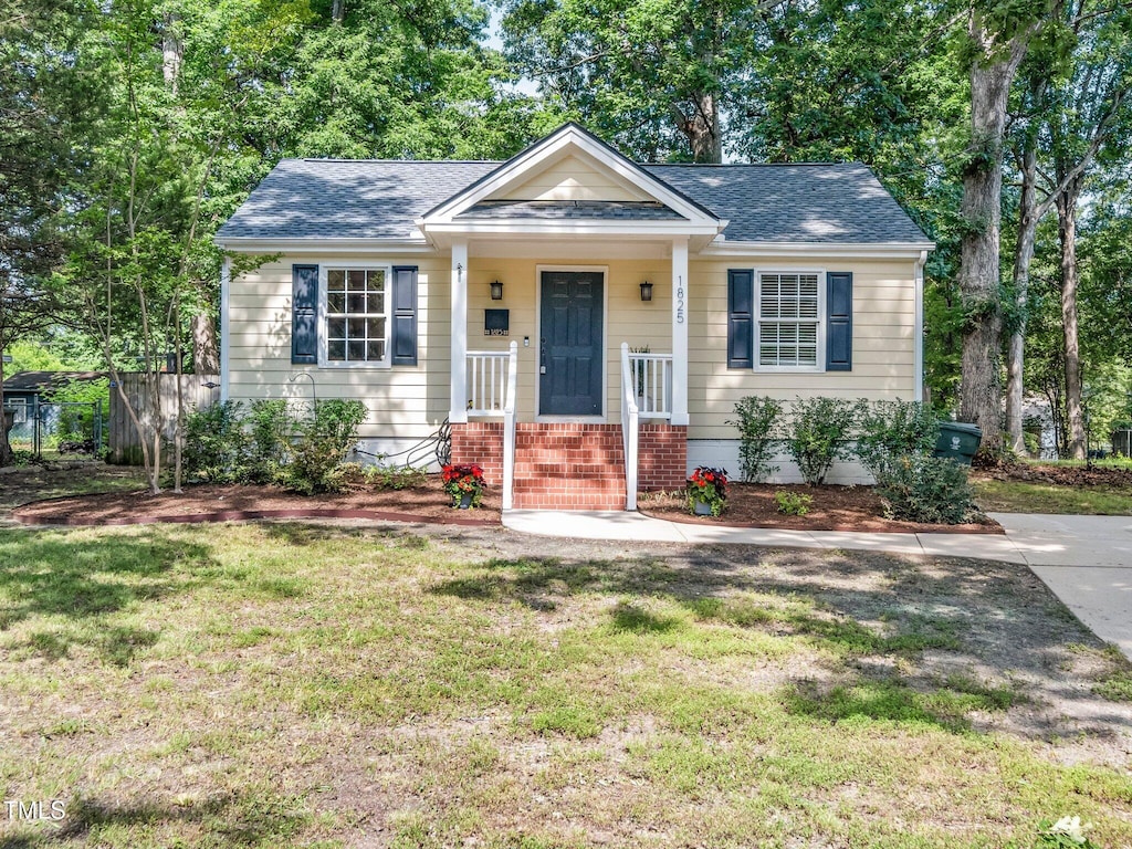 1825 Watkins St, Raleigh, NC 27604 - bungalow with a front yard, a shingled roof, and brick siding
