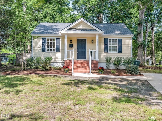 1825 Watkins St, Raleigh, NC 27604 - bungalow with a front yard, a shingled roof, and brick siding