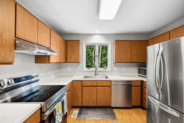 113 Twisted Oak Pl, Durham, NC 27705 - kitchen with appliances with stainless steel finishes, ventilation hood, light wood finished floors, and light countertops