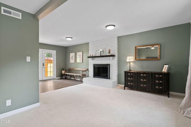 5400 Kaplan Dr, Raleigh, NC 27606 - living room featuring carpet flooring and a brick fireplace
