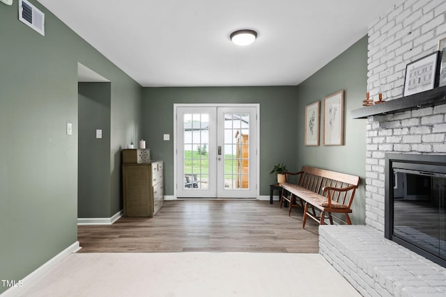 5400 Kaplan Dr, Raleigh, NC 27606 - entryway with french doors, wood finished floors, and a fireplace