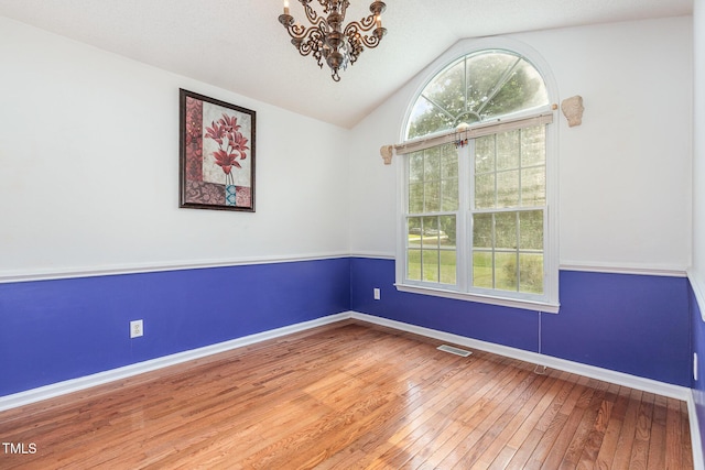 2312 Buckstone Ct, Fuquay Varina, NC 27526 - unfurnished room with a chandelier, hardwood / wood-style flooring, and lofted ceiling