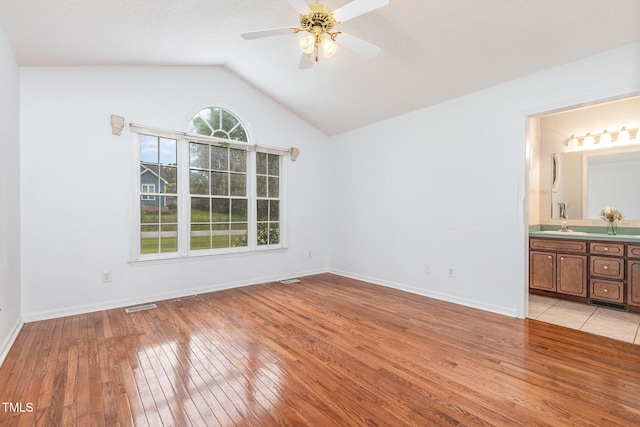 2312 Buckstone Ct, Fuquay Varina, NC 27526 - unfurnished bedroom featuring light wood finished floors, lofted ceiling, ensuite bathroom, and ceiling fan