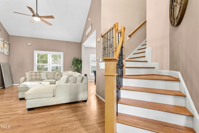5301 Denmead Way, Raleigh, NC 27613 - living room featuring wood finished floors, a ceiling fan, high vaulted ceiling, and stairs