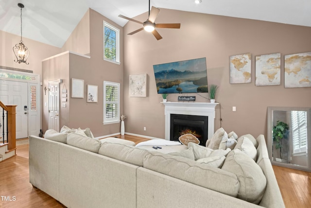 5301 Denmead Way, Raleigh, NC 27613 - living area with high vaulted ceiling, a warm lit fireplace, light wood finished floors, a ceiling fan, and plenty of natural light