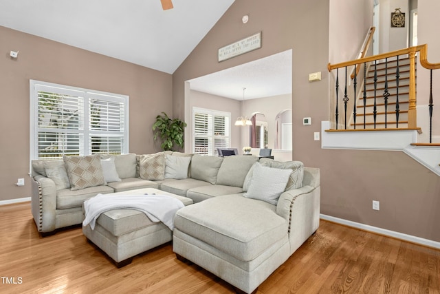 5301 Denmead Way, Raleigh, NC 27613 - living room featuring wood finished floors, a chandelier, high vaulted ceiling, stairway, and arched walkways