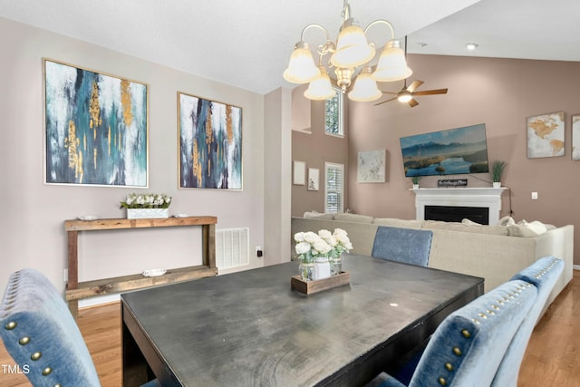 5301 Denmead Way, Raleigh, NC 27613 - dining area featuring wood finished floors, a chandelier, a fireplace, and high vaulted ceiling