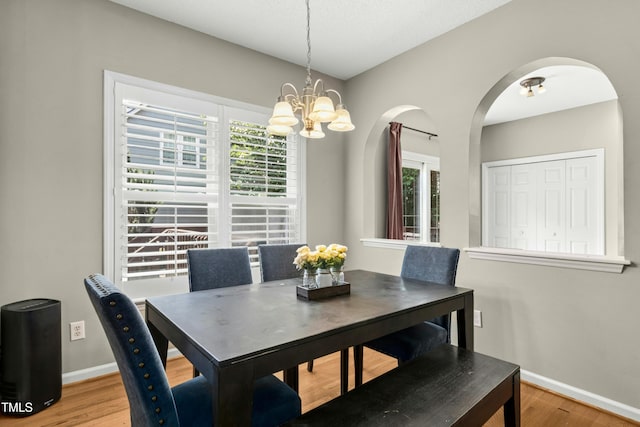 5301 Denmead Way, Raleigh, NC 27613 - dining room featuring a chandelier, wood finished floors, and arched walkways