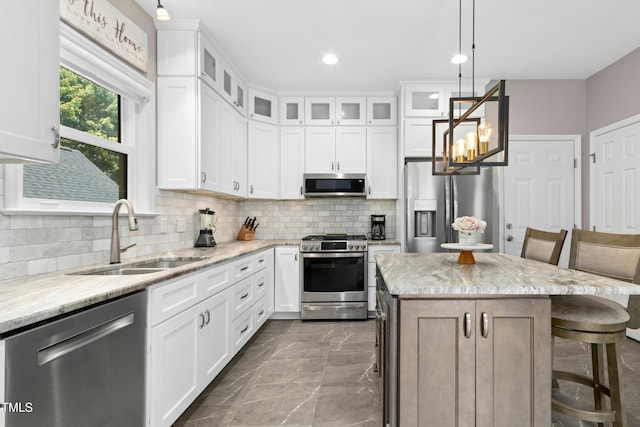 5301 Denmead Way, Raleigh, NC 27613 - kitchen with appliances with stainless steel finishes, decorative backsplash, pendant lighting, glass insert cabinets, and a kitchen bar
