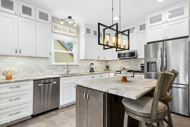 5301 Denmead Way, Raleigh, NC 27613 - kitchen featuring stainless steel appliances, white cabinets, a kitchen breakfast bar, a kitchen island, and backsplash