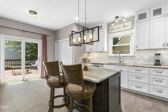 5301 Denmead Way, Raleigh, NC 27613 - kitchen with marble look tiles, backsplash, a kitchen island, white cabinetry, and light stone countertops