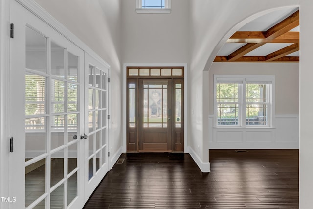 6332 Mountain Oaks Way, Wake Forest, NC 27587 - entrance foyer featuring french doors, dark wood-type flooring, arched walkways, beam ceiling, and a wainscoted wall