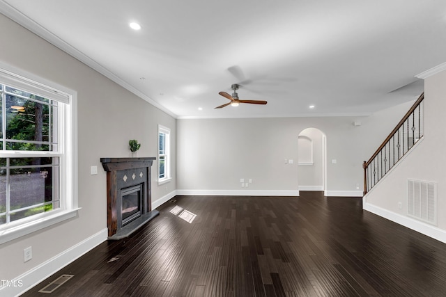 6332 Mountain Oaks Way, Wake Forest, NC 27587 - unfurnished living room featuring plenty of natural light, arched walkways, stairs, a glass covered fireplace, and recessed lighting