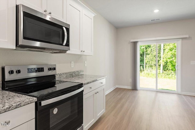 94 Taverners Ln, Angier, NC 27501 - kitchen featuring appliances with stainless steel finishes, light wood-style flooring, white cabinets, light stone countertops, and recessed lighting