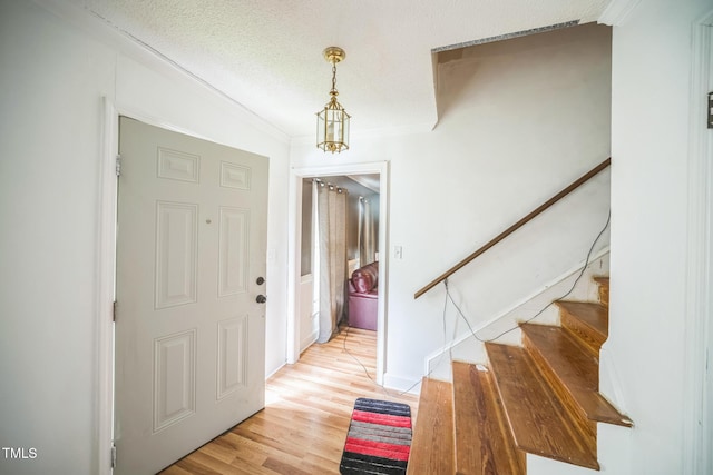2504 Lancaster Rd NW, Wilson, NC 27896 - entrance foyer featuring crown molding, stairway, light wood finished floors, and a textured ceiling