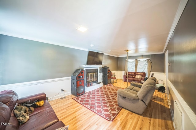 2504 Lancaster Rd NW, Wilson, NC 27896 - living area with ornamental molding, a glass covered fireplace, a wainscoted wall, and wood finished floors