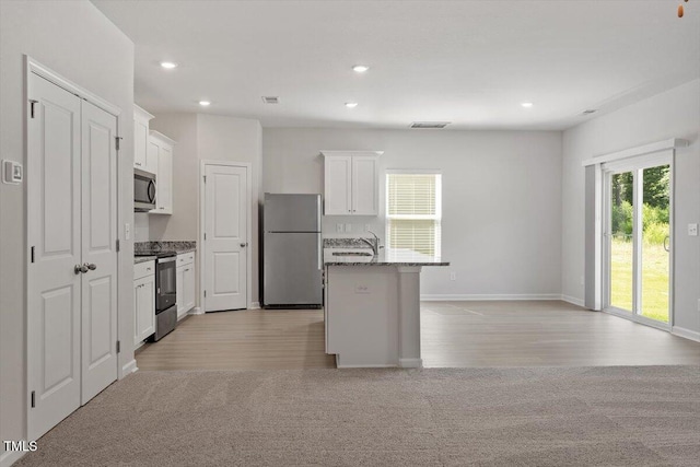 154 Taverners Ln, Angier, NC 27501 - kitchen featuring appliances with stainless steel finishes, white cabinetry, light colored carpet, an island with sink, and recessed lighting