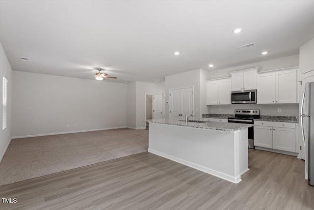 154 Taverners Ln, Angier, NC 27501 - kitchen with stainless steel appliances, ceiling fan, light wood-type flooring, white cabinetry, and light stone counters