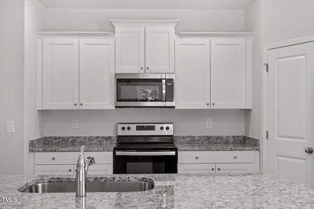 154 Taverners Ln, Angier, NC 27501 - kitchen with stainless steel microwave, electric range, white cabinets, and light stone counters