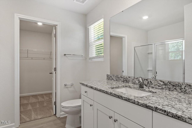 154 Taverners Ln, Angier, NC 27501 - full bathroom with wood finished floors, a walk in closet, vanity, and plenty of natural light