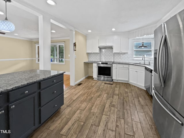 3205 Marita Dr, Fayetteville, NC 28301 - kitchen featuring appliances with stainless steel finishes, white cabinetry, dark wood-type flooring, tasteful backsplash, and ornamental molding