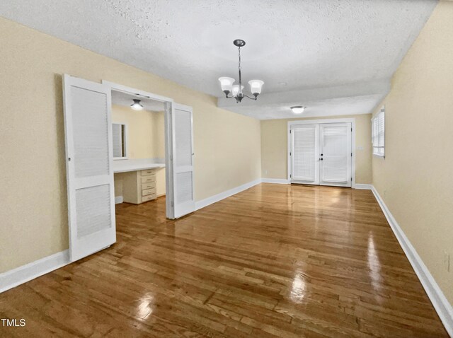 3205 Marita Dr, Fayetteville, NC 28301 - empty room featuring a textured ceiling, wood finished floors, and a chandelier
