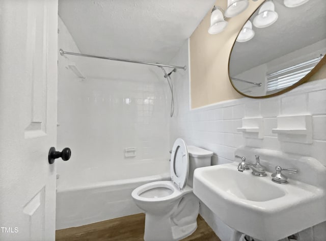 3205 Marita Dr, Fayetteville, NC 28301 - bathroom featuring  shower combination, wood finished floors, tile walls, and a wainscoted wall