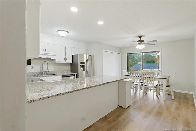 3511 Rolls Ave, Fayetteville, NC 28311 - kitchen with appliances with stainless steel finishes, a ceiling fan, a peninsula, white cabinets, and light stone countertops