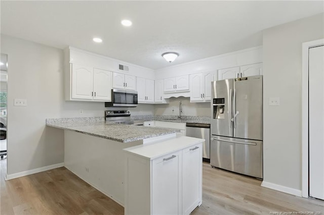 3511 Rolls Ave, Fayetteville, NC 28311 - kitchen with appliances with stainless steel finishes, a peninsula, white cabinets, light wood finished floors, and recessed lighting