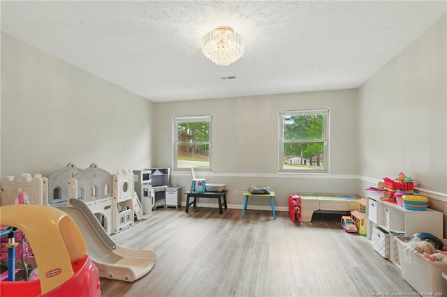 3511 Rolls Ave, Fayetteville, NC 28311 - playroom with wood finished floors, a chandelier, and a textured ceiling