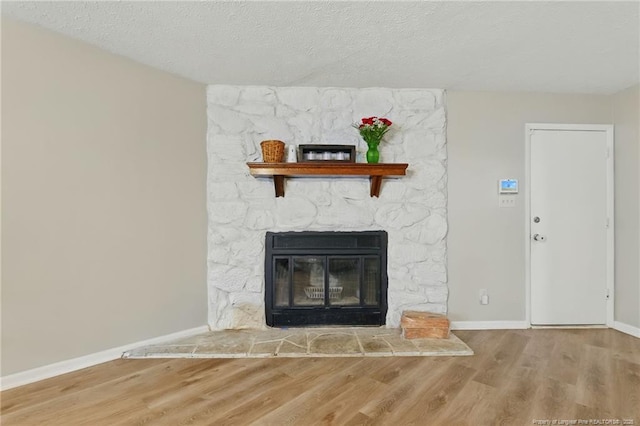 3511 Rolls Ave, Fayetteville, NC 28311 - detailed view of wood finished floors, a stone fireplace, and a textured ceiling
