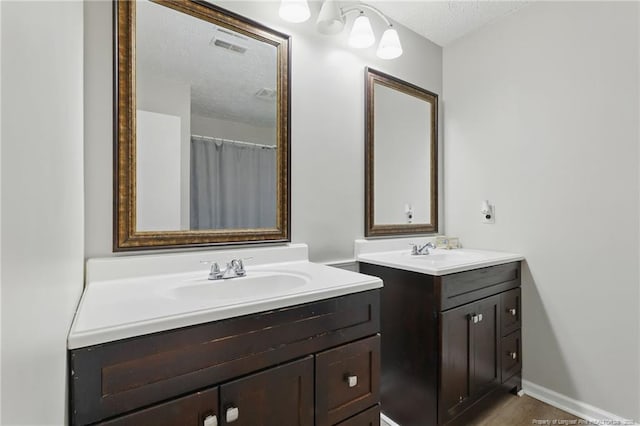 3511 Rolls Ave, Fayetteville, NC 28311 - bathroom featuring two vanities and a textured ceiling