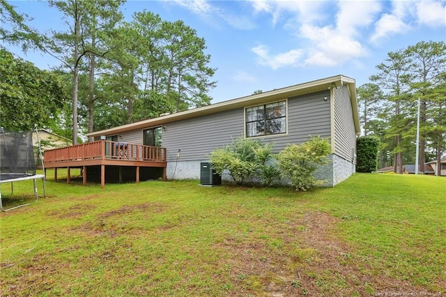 3511 Rolls Ave, Fayetteville, NC 28311 - back of house with a trampoline, a wooden deck, and a lawn