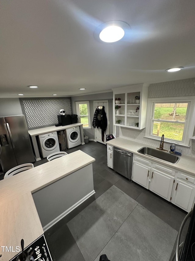 5809 Iris Lake Ct, Raleigh, NC 27604 - kitchen with stainless steel appliances, washer / dryer, white cabinetry, backsplash, and recessed lighting